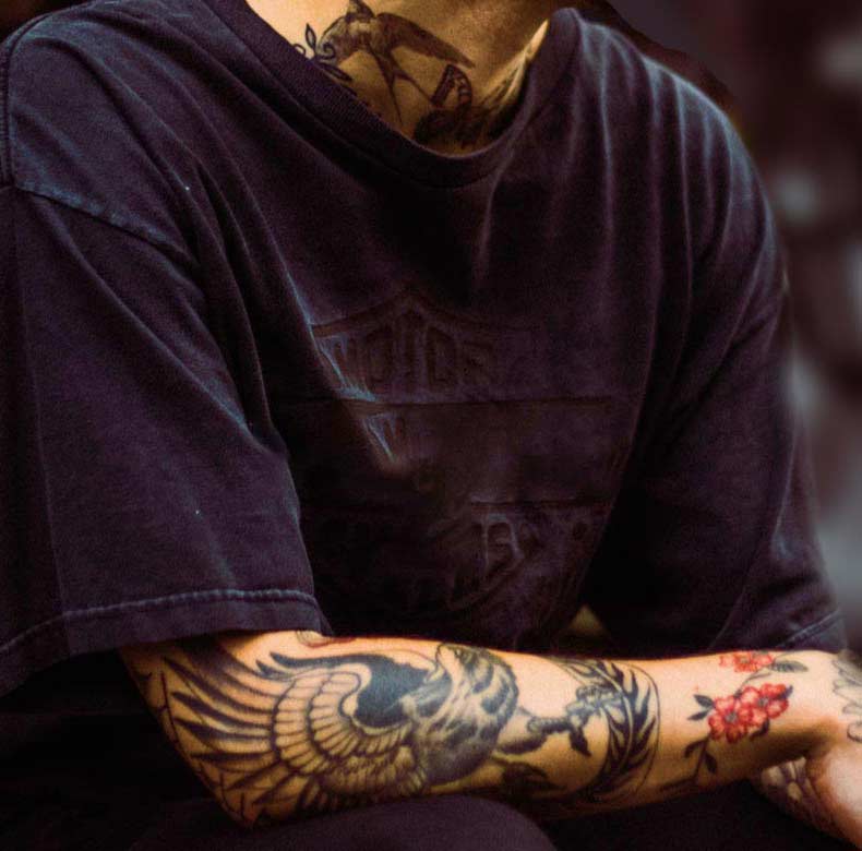 Person with Tattoos on Arm and Neck Person with Tattoos on Arm and Neck